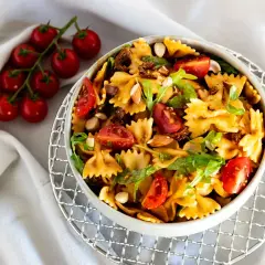 Mediterraner Salat mit getrockneten Tomaten und Rucola, garniert mit Mandeln und frischen Kirschtomaten. Ein köstliches Gericht.
