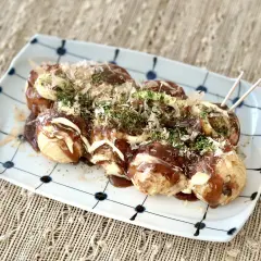 A plate of takoyaki, drizzled with sauce and mayonnaise, topped with bonito flakes and nori. Perfect for a homemade takoyaki sauce recipe.