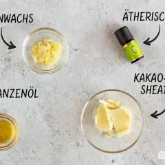 Zutaten für selbstgemachte Lotion: Bienenwachs, Pflanzenöl, Kakaobutter und ätherisches Öl.