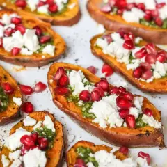 Pieczone bataty z piekarnika, udekorowane zielonym pesto, fetą i pestkami granatu. Pyszna przekąska!