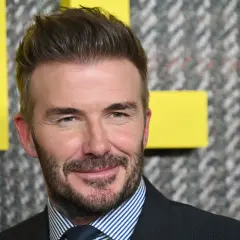 David Beckham sfoggia un taglio corto elegante uomo, con barba curata e un sorriso accattivante.