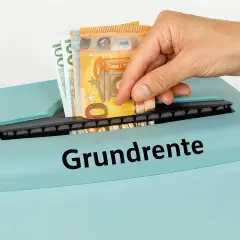 Geld wird in einen Aktenvernichter mit der Aufschrift "Grundrente" gesteckt. Dies symbolisiert die Sorge um die Mindestrente in Deutschland.