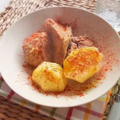 Un plato de carne o caldeiro con patatas, espolvoreado con pimentón.