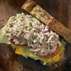 Pyszna kanapka z chleba pełnoziarnistego z obfitą porcją fit pasty z tuńczyka, sałatą, pomidorem i serem.