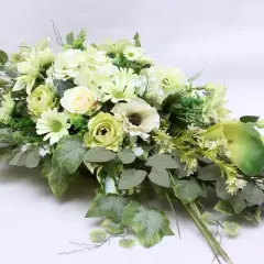 Elegancki bukiet z białych i zielonych kwiatów, idealny jako ozdoba na cmentarz.