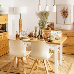 Przytulna jadalnia w stylu boho z drewnianymi meblami, białymi krzesłami i dekoracjami z traw.