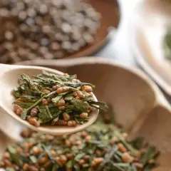 Holzschaufel mit Genmaicha Tee, dessen Wirkung durch gerösteten Reis und grünen Tee entsteht.