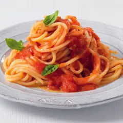 Un piatto di pasta con pomodorini freschi e basilico, un classico della cucina italiana.