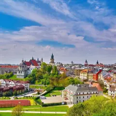 Widok na zabytkowe miasto na Lubelszczyźnie z kościołami i kolorowymi kamienicami pod błękitnym niebem.