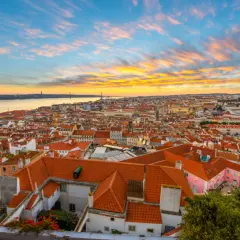 Un espectacular atardecer lisboa baña con tonos dorados y rosados el cielo sobre la ciudad y el río Tajo.