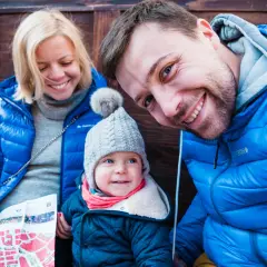 Rodzina zwiedza Lwów na Ukrainie. Uśmiechnięci rodzice i dziecko z mapą.