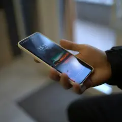 Dłoń trzyma smartfon Samsung. Chcesz wiedzieć, jak wyłączyć dźwięk klawiatury Samsung?