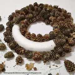 Ozdobny wianek z szyszek, idealny na ślubne dekoracje. Naturalne szyszki tworzą rustykalny urok.