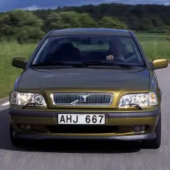 Złoty Volvo S40 jedzie po wiejskiej drodze. Skąd jest to Volvo? Z pewnością z krainy spokoju i zieleni.