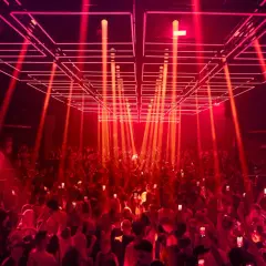 Folla in delirio sotto un gioco di luci rosse e laser al **Hï Ibiza**. L'energia della notte vibra tra la gente.