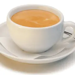 Ein kleiner brauner Kaffee mit Milchschaum in einer weißen Tasse auf einer Untertasse.