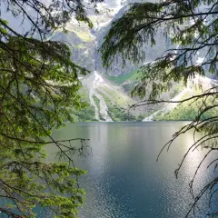 Widok na Morskie Oko, gdzie góry odbijają się w tafli wody. To miejsce, gdzie rodzi się legenda o morskim oku.