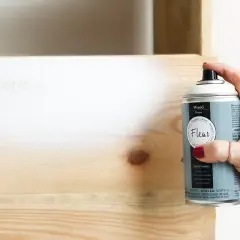 Mano spruzza primer legno per preparare la superficie prima della verniciatura. Utile per uniformare e far aderire meglio il colore.