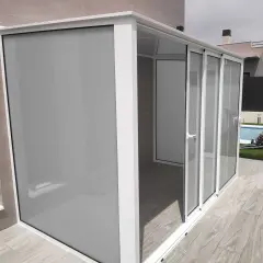 Moderno cierre para balcones y terrazas con puertas correderas de cristal y panel opaco.