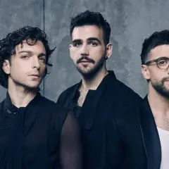 Tre uomini in abiti scuri, pronti per il volo.
