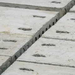 Reihen von Betonplatten mit rechteckigen Aussparungen. Die faserbeton mindestdicke ist hier gut erkennbar.