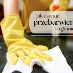 Rękawiczka w żółtej gumie poleruje ciemny granit, usuwając mokre plamy i przebarwienia.