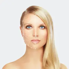 Kobieta z niebieskimi oczami i blond włosami, na jej twarzy widoczna siatka geometryczna. Sprawdź wolumetria twarzy cena.