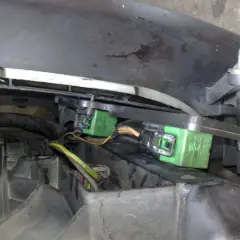 Zielone przekaźniki wentylatora chłodnicy w Peugeot 206, zamontowane pod maską, blisko reflektora.