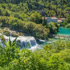 Wodospady Krka w Chorwacji, z turkusową wodą, kaskadami i mostkiem pełnym ludzi.