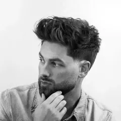 Dos cortes de pelo masculinos: un taper fade con diseño y un fade más pronunciado.