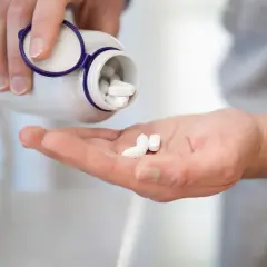 Dłoń z tabletkami magnezu. Pamiętaj, z czym nie łączyć magnezu, by uniknąć interakcji.