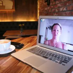 Kawa i laptop z rozmową przez Skype. Dowiedz się, jak zainstalować Skype na komputerze, by połączyć się z bliskimi.
