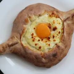 Chaczapuri adżarskie, jeden z popularnych rodzajów chaczapuri, z serem i surowym jajkiem na wierzchu.