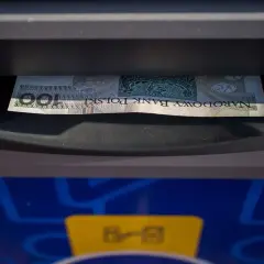 Jednorazowa wpłata gotówki do bankomatu. Banknot 100 zł wchodzi do szczeliny.