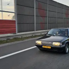 Czarny Citroën BX z zabytkowymi tablicami rejestracyjnymi jedzie autostradą.