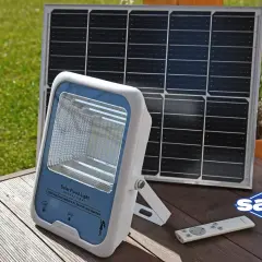 Lampa solarna i panel słoneczny na drewnianym tarasie. Dowiedz się, jak naładować lampę solarną bez słońca, korzystając z alternatywnych metod ładowania.