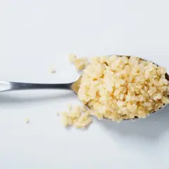Ein Löffel voll gekochter Quinoa, bereit für eine gesunde Mahlzeit.