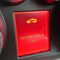 Wyświetlacz w Oplu Astrze H z komunikatem "Service Vehicle Soon" i ikoną samochodu.