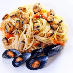 Spaghetti alla tarantina con cozze e pomodorini, un piatto di mare saporito e colorato.
