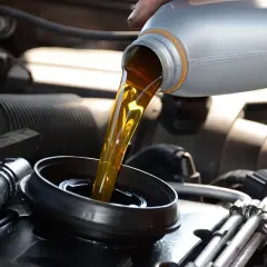 Vertiendo aceite nuevo en el motor de un coche. Es importante mezclar aceites coche para mantener el motor en buen estado.