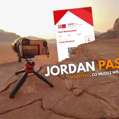 Jordan Pass kosztuje 70 JOD. Aparat na statywie na tle pustyni i karta Jordan Pass.