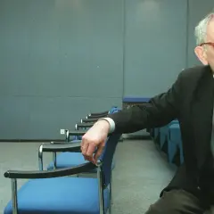 Krzysztof Kieślowski, reżyser znany z głębokich filmów, siedzi w pustej sali.