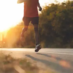 Läufer auf einer Straße im Sonnenuntergang, intensive **Vorbereitung Halbmarathon**.