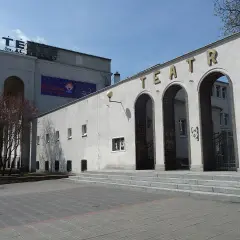 Teatr im. A. Fredry w Gnieźnie, z charakterystycznymi arkadami i napisem na fasadzie, zaprasza na kolejne spektakle.