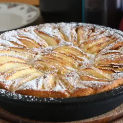 Torta di mele in friggitrice ad aria, dorata e cosparsa di zucchero a velo, pronta per essere gustata.