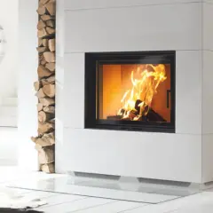 Moderner Kamin mit brennendem Feuer. Holzstapel daneben. Unterschied zwischen Zeitbrand und Dauerbrand ist hier nicht ersichtlich.