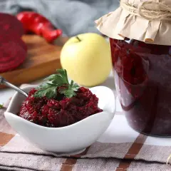 Słoik z przetworami z buraków, idealnych jako buraki pastewne dla kur. Obok miseczka z pastą buraczaną i świeże buraki.