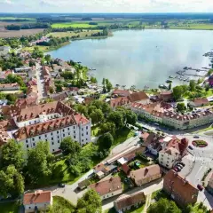 Widok z lotu ptaka na miasteczko nad jeziorem, z zamkiem i mariną. Nietypowe atrakcje Mazur czekają!