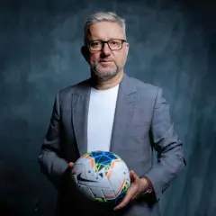 Jerzy Brzęczek, były selekcjoner kadry narodowej piłkarzy, trzyma piłkę nożną.