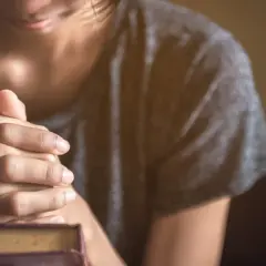 Dłonie złożone w modlitwie nad Biblią. Cicha modlitwa o opamiętanie męża, o powrót do Boga i rodziny.